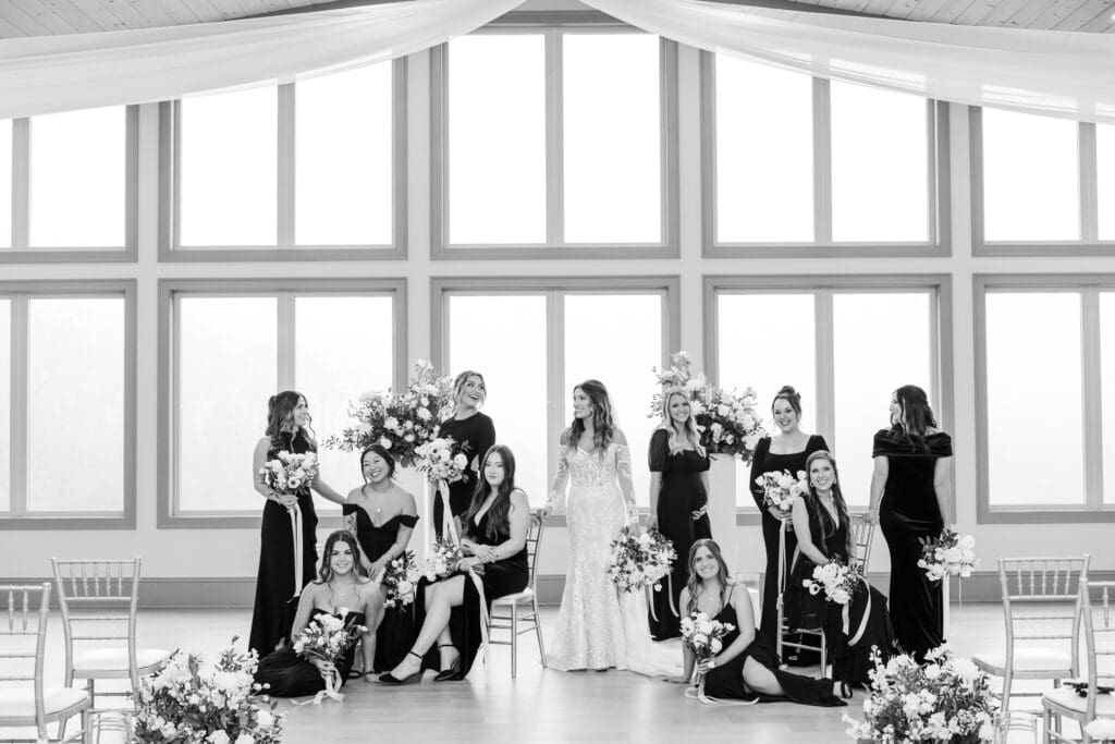 Bride in lace gown with bridesmaids holding bouquets inside Venue In The Vines’ airy ceremony space.