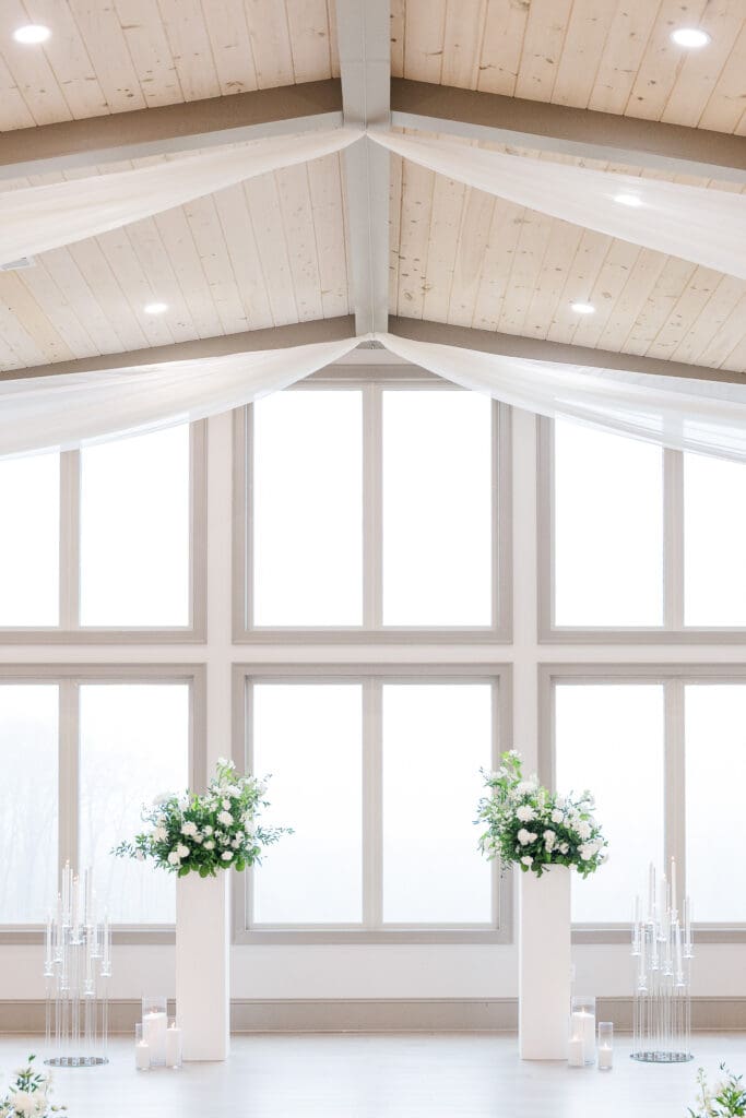 Atlanta wedding photographer captures soft ceremony floral pillars and candles at Venue In The Vines.